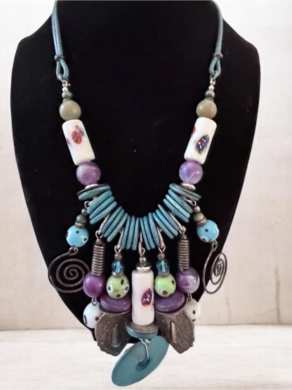 a handcrafted artisan statement necklace featuring turquoise-colored disks